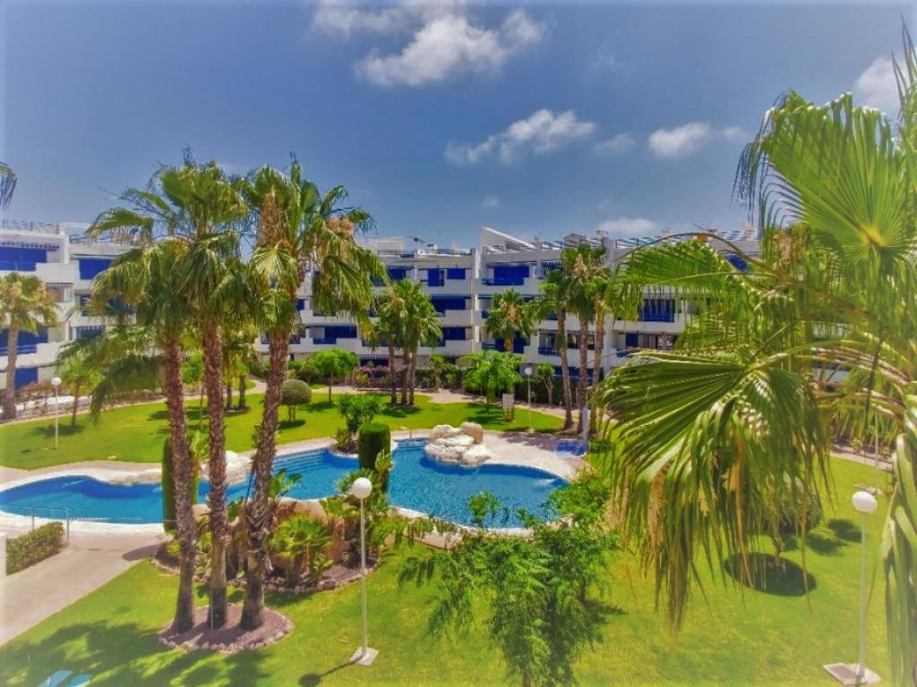 uma vista aérea de um resort com uma piscina e palmeiras em South facing Casa Bonnie em Playa Flamenca