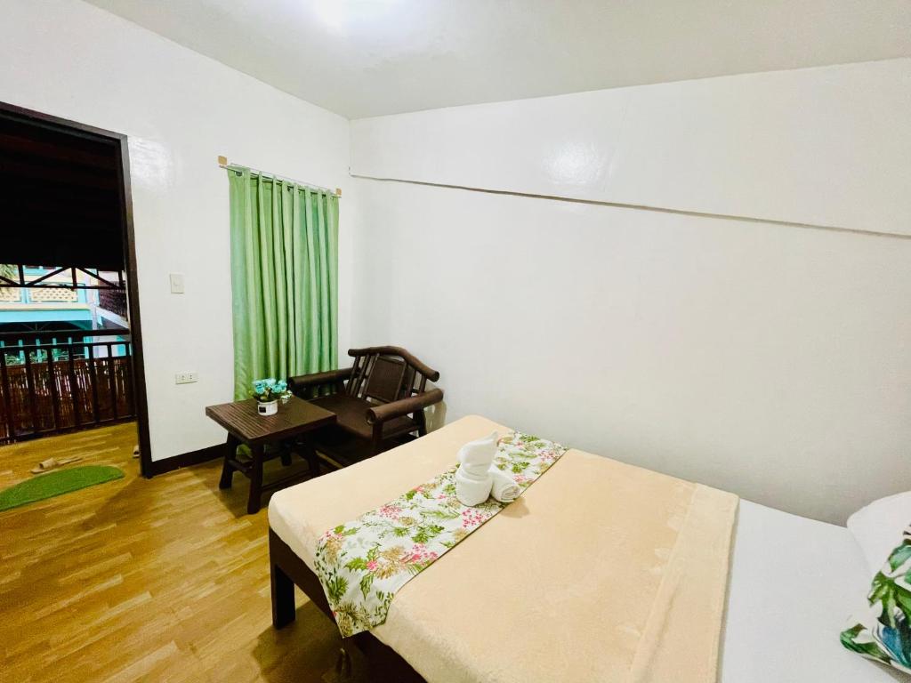 mały pokój z łóżkiem i krzesłem w obiekcie Amancio's Balai - Near the Airport, City Center! w mieście Puerto Princesa