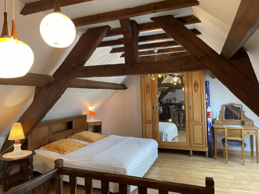 ein Schlafzimmer mit einem großen Bett und einem Spiegel in der Unterkunft Gîte Arfeuilles, 4 pièces, 6 personnes - FR-1-489-277 in Arfeuilles