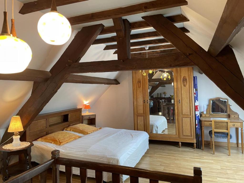 a bedroom with a large bed and a mirror at Charmante maison familiale avec cour fermée, proche randonnées et sites naturels - FR-1-489-277 in Arfeuilles