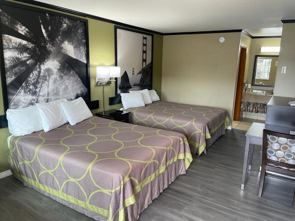ein Hotelzimmer mit 2 Betten und einem Tisch in der Unterkunft Super 8 by Wyndham Crescent City in Crescent City