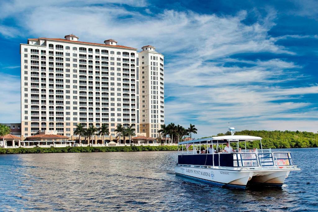 a boat in the water in front of a large building at The Westin Cape Coral Resort at Marina Village in Cape Coral