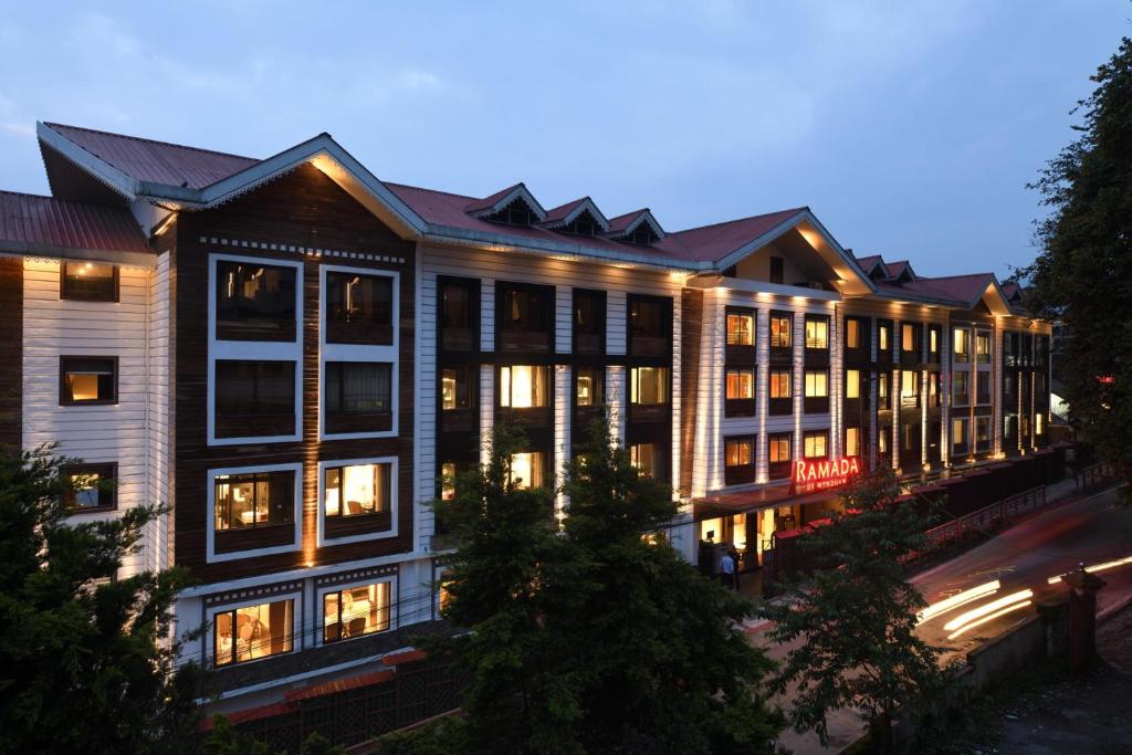ガントクにあるRamada by Wyndham Gangtok Hotel & Casino Goldenの夜にたくさんの窓がある大きな建物