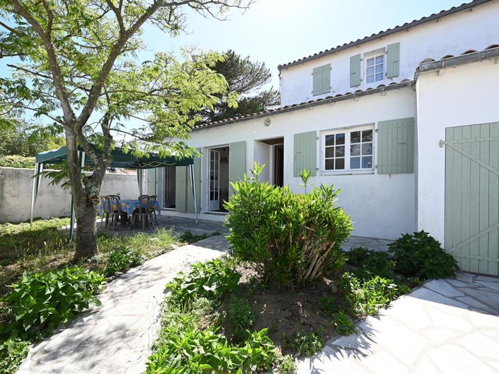 Casa blanca con un árbol y un patio en Maison Ars-en-Ré, 3 pièces, 4 personnes - FR-1-434-101, en Ars-en-Ré