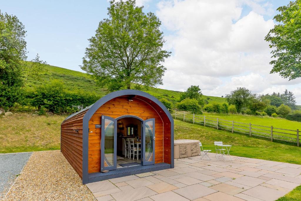 a small shed with an open door in a field at Stiperstones Pod in Shrewsbury