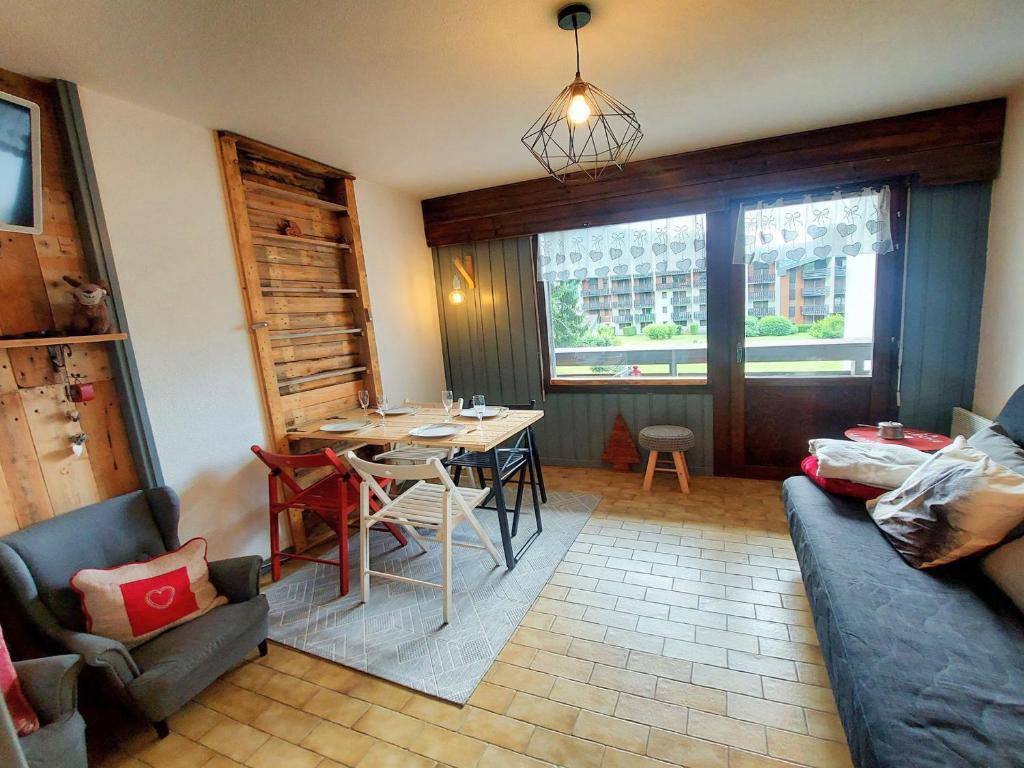 un salon avec une table et un canapé dans l'établissement Charmant Studio au Centre de Samoëns - Balcon Exposé Sud, Parking et Animaux Acceptés - FR-1-624-110, à Samoëns