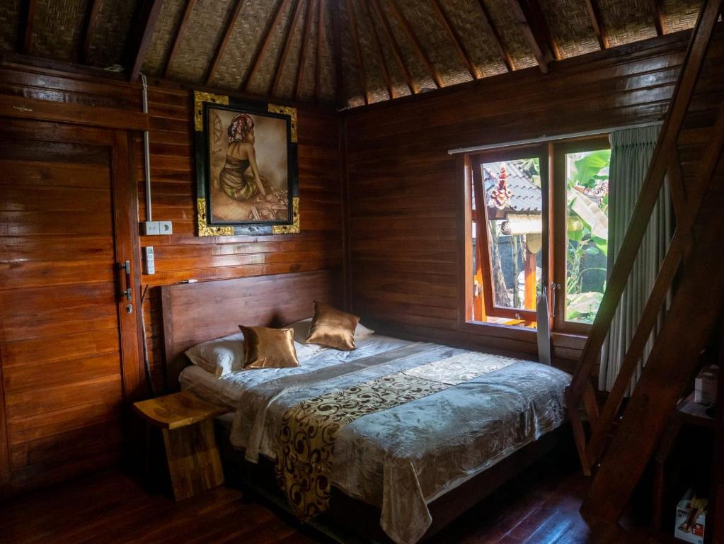 een slaapkamer met een bed in een houten kamer bij Pondok Biu in Denpasar