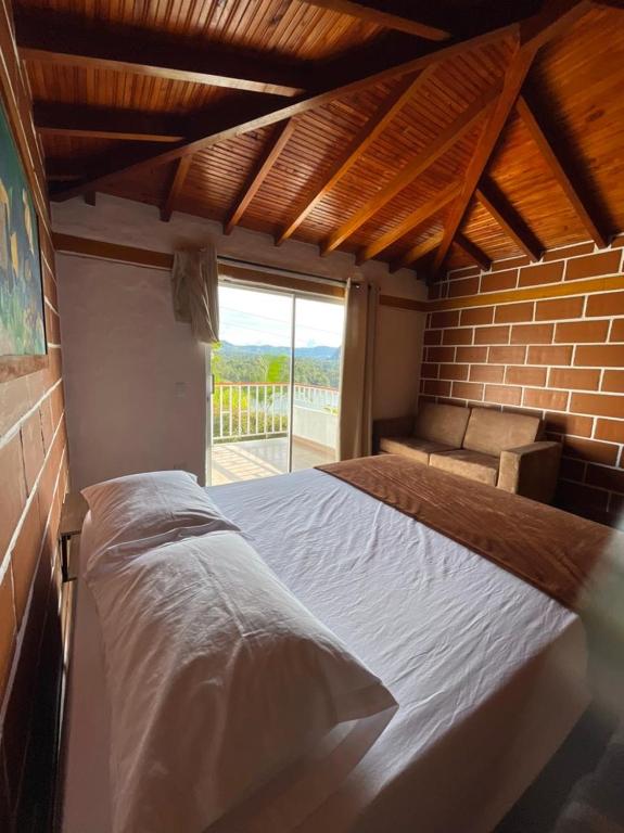 a large bed in a room with a brick wall at Finca-hotel Montecarlo Guatape by Hope in Guatapé