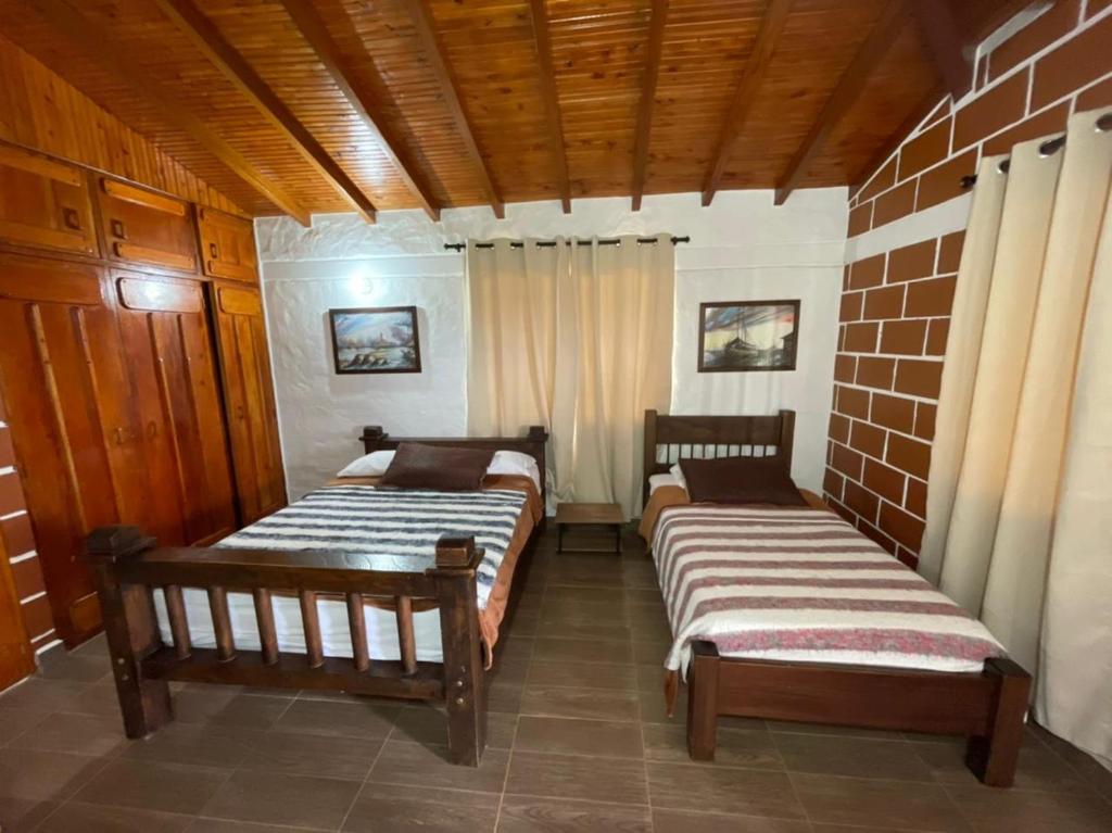 two beds sitting in a room with at Finca-hotel Montecarlo Guatape by Hope in Guatapé