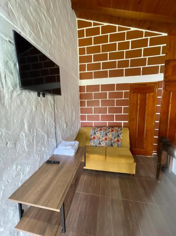 a couch in a room with a brick wall at Finca-hotel Montecarlo Guatape by Hope in Guatapé