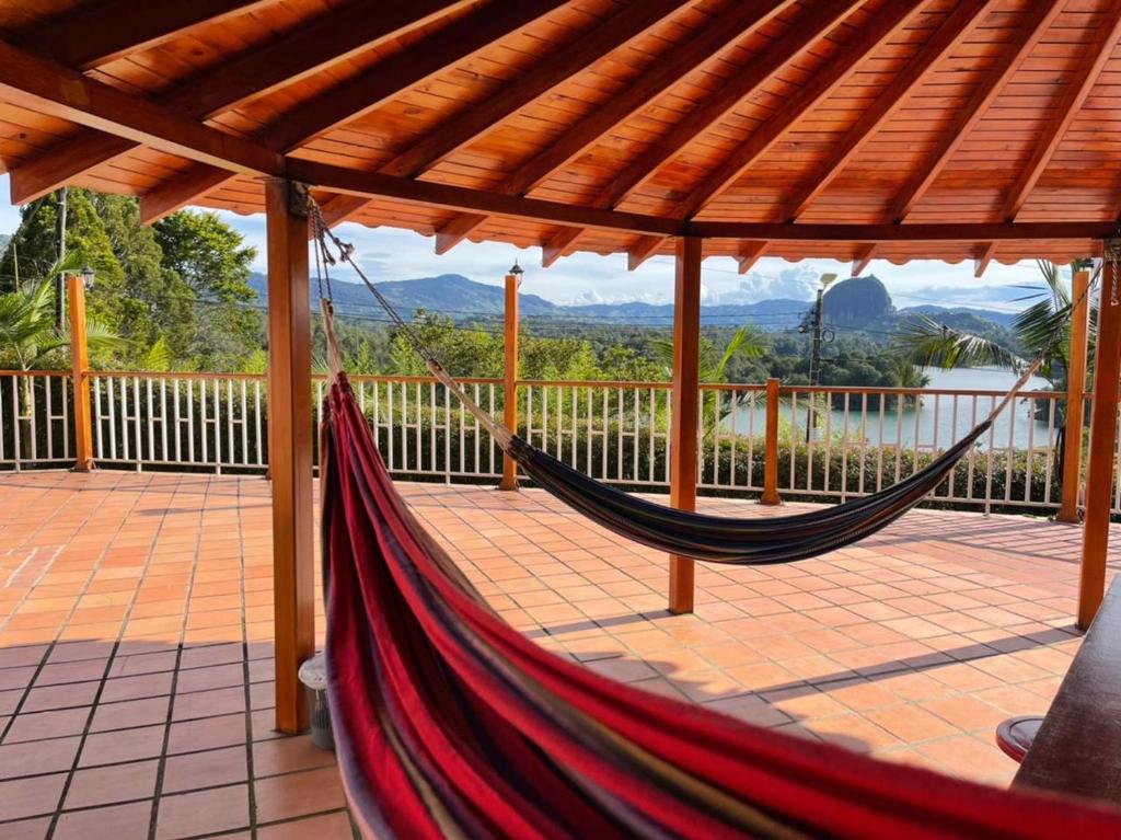 a hammock on a deck with a view of the water at Finca-hotel Montecarlo Guatape by Hope in Guatapé