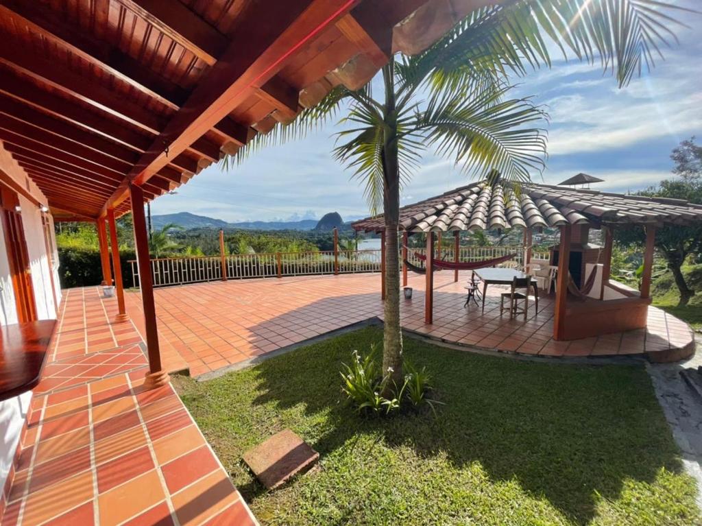 a patio with a table and a palm tree at Finca-hotel Montecarlo Guatape by Hope in Guatapé
