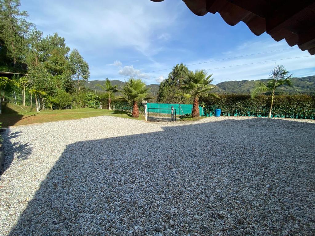 a gravel driveway with trees and a green building at Finca-hotel Montecarlo Guatape by Hope in Guatapé