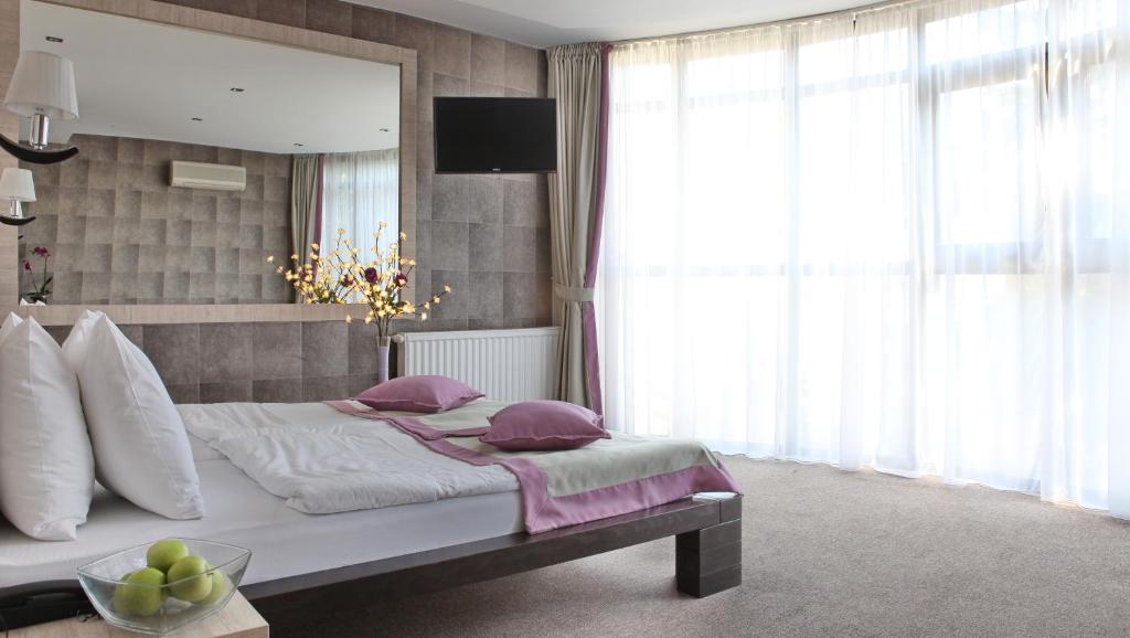 Postel nebo postele na pokoji v ubytování Garni Hotel Vozarev