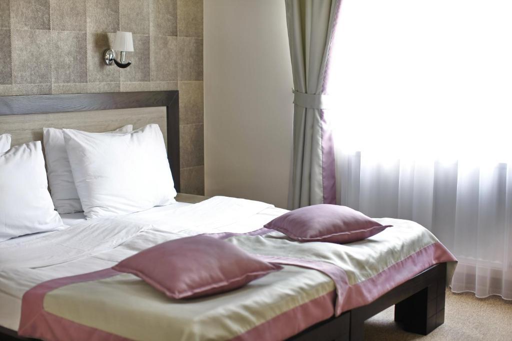 Postel nebo postele na pokoji v ubytování Garni Hotel Vozarev