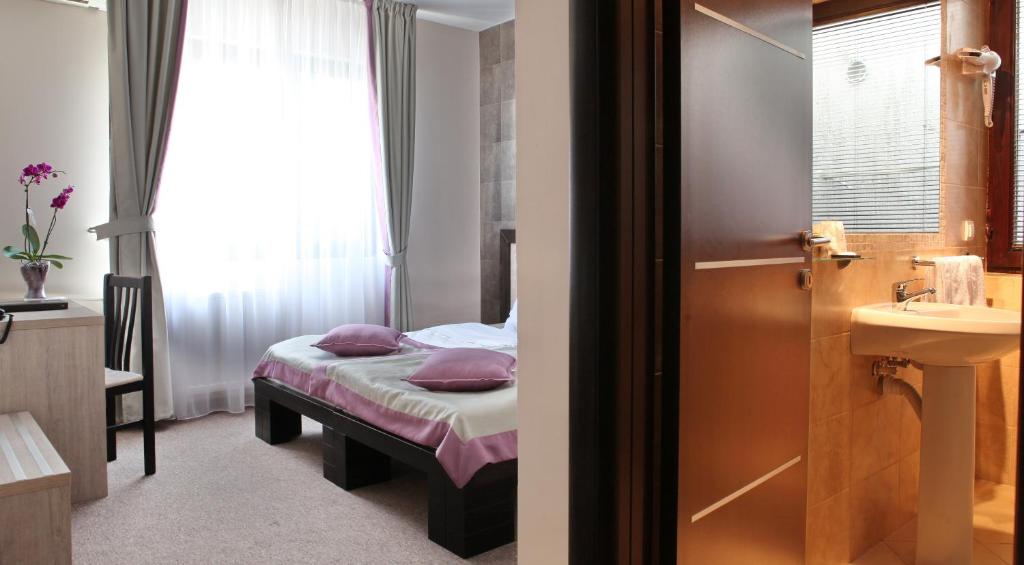 Postel nebo postele na pokoji v ubytování Garni Hotel Vozarev