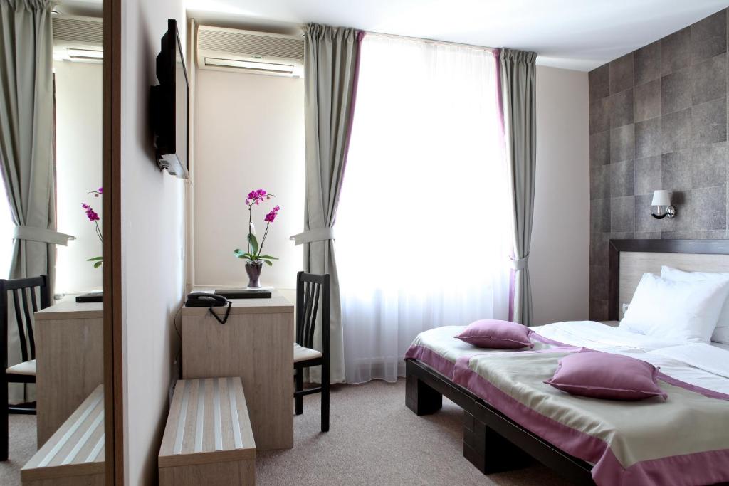 Postel nebo postele na pokoji v ubytování Garni Hotel Vozarev