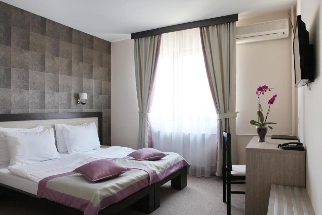 Postel nebo postele na pokoji v ubytování Garni Hotel Vozarev