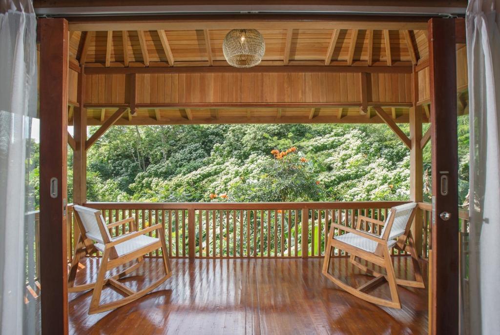 - deux chaises sur une terrasse couverte avec vue sur la forêt dans l'établissement Giriwood Hotel & Villa, à Munduk