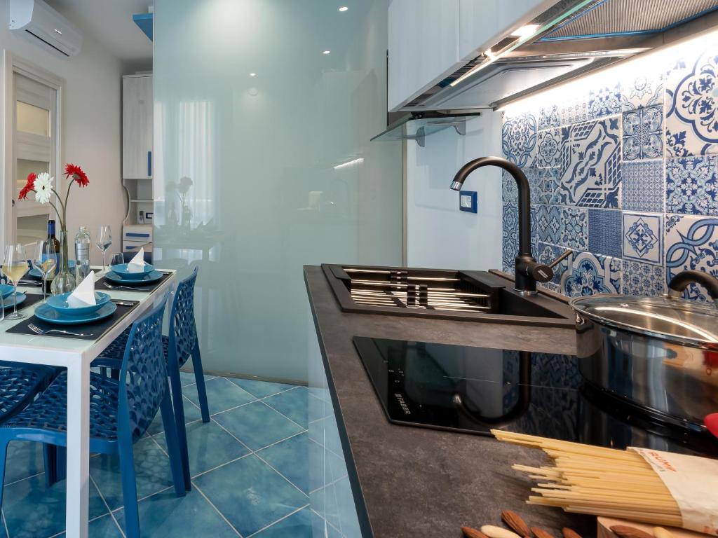 a kitchen with a sink and a counter with a table at IL FARO E LA LUNA Beach Apartments in San Vito lo Capo