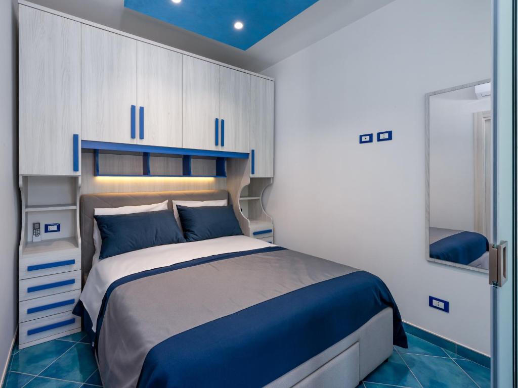 a bedroom with a bed and cabinets and a mirror at IL FARO E LA LUNA Beach Apartments in San Vito lo Capo