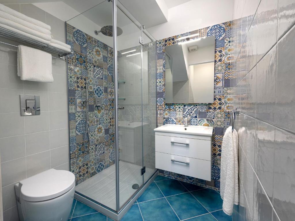 a bathroom with a shower and a toilet and a sink at IL FARO E LA LUNA Beach Apartments in San Vito lo Capo