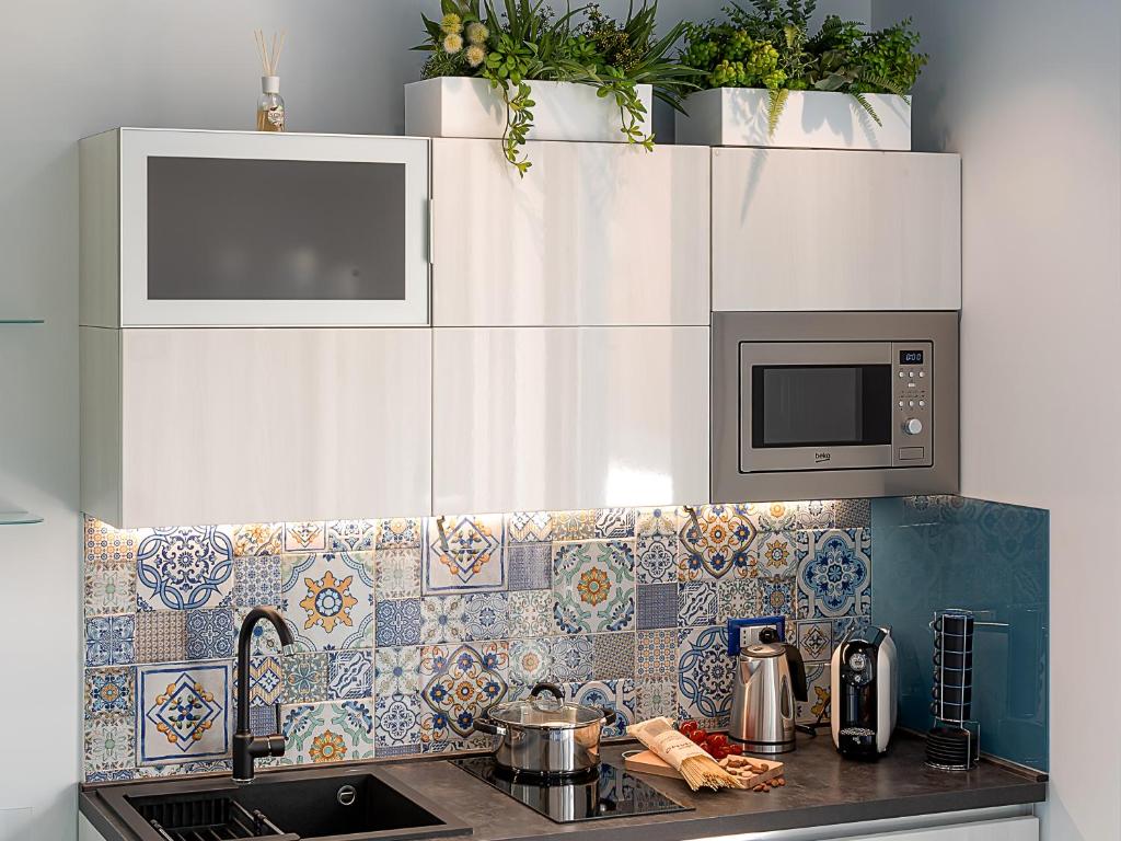 a kitchen with a sink and a microwave at IL FARO E LA LUNA Beach Apartments in San Vito lo Capo