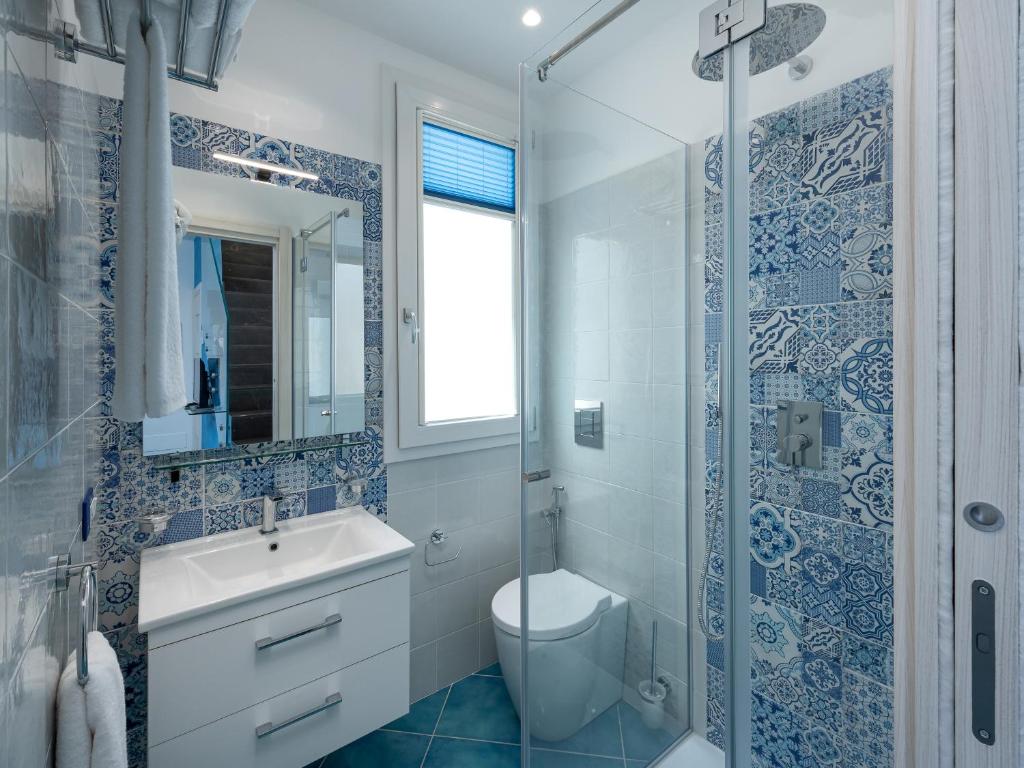 a bathroom with a toilet and a sink and a shower at IL FARO E LA LUNA Beach Apartments in San Vito lo Capo