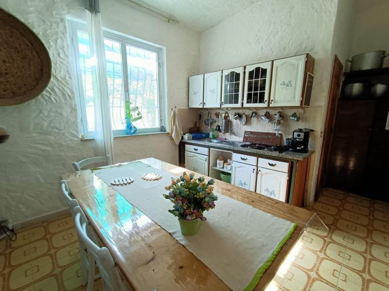 eine Küche mit einem Tisch und einer Blumenvase darauf in der Unterkunft Ghiramonte, vita in campagna a due passi dal mare in Siniscola