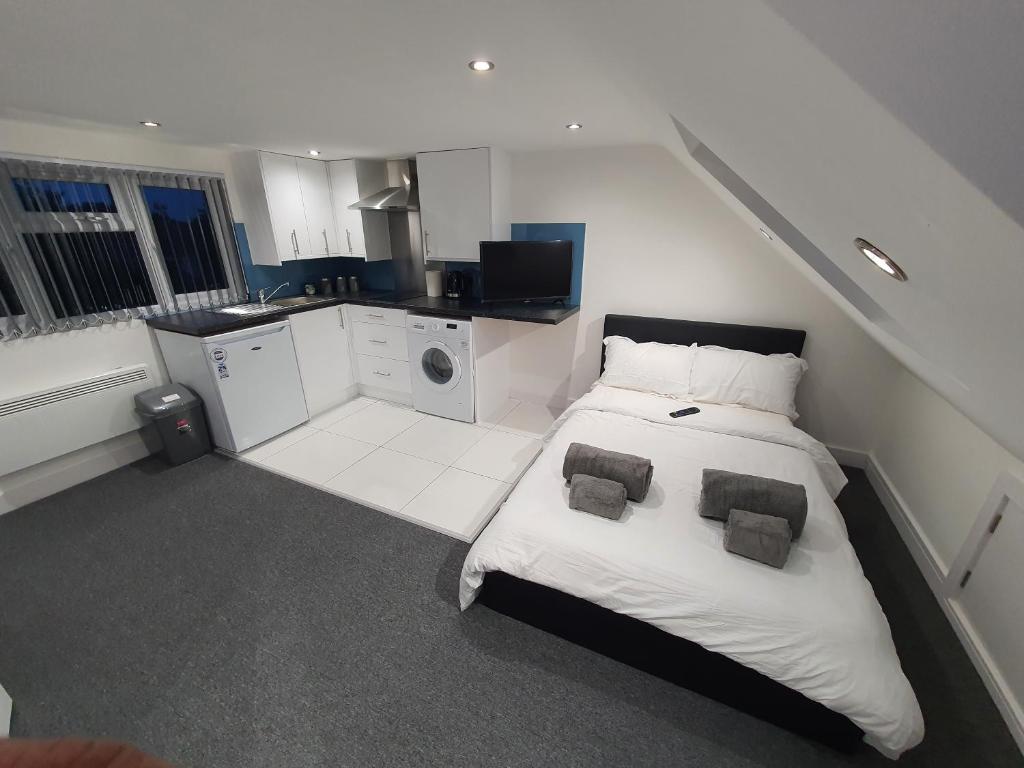 New Self Contained Flat,in Hayes, Free Parking في Northolt: غرفة بيضاء كبيرة مع سرير ومطبخ
