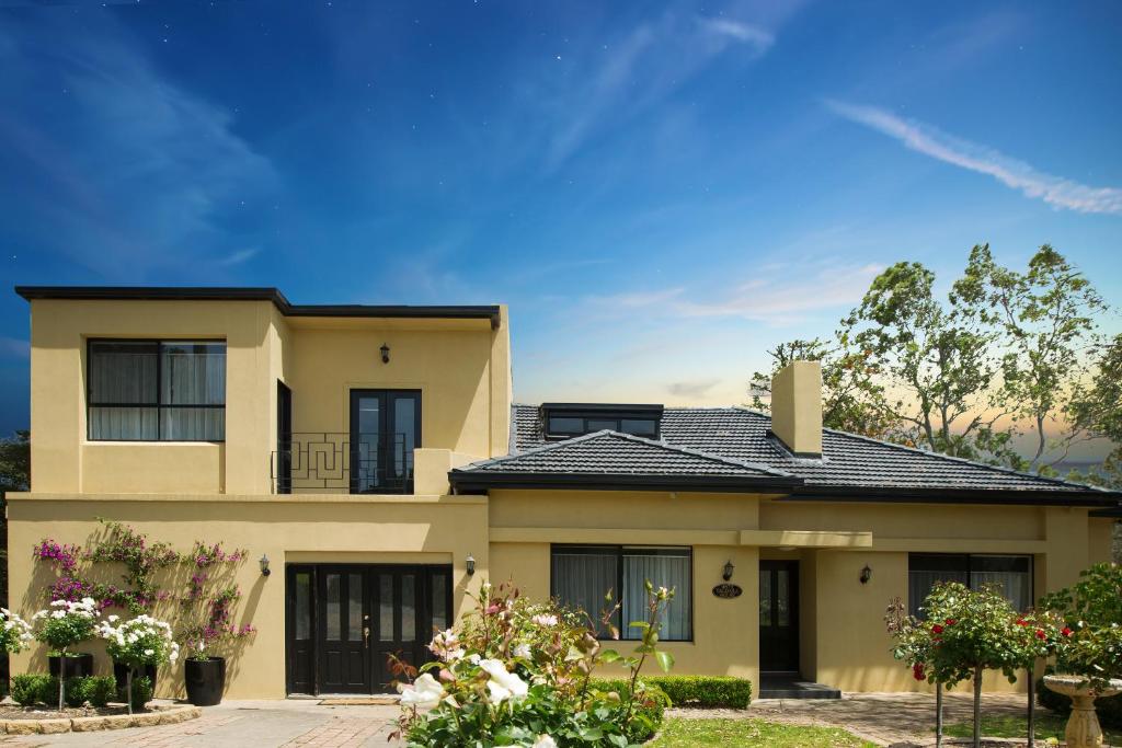 a large yellow house with a black roof at Chateau Yaldara House in Lyndoch