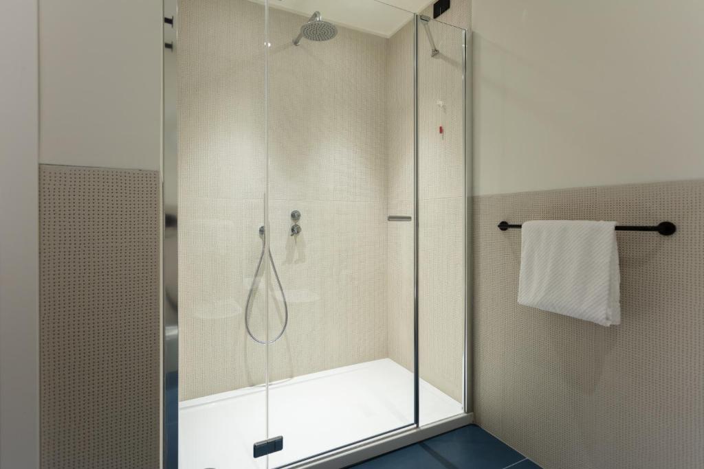 W łazience znajduje się prysznic ze szklanymi drzwiami. w obiekcie Sant'Ambrogio Apartments, Reception h24 w Mediolanie