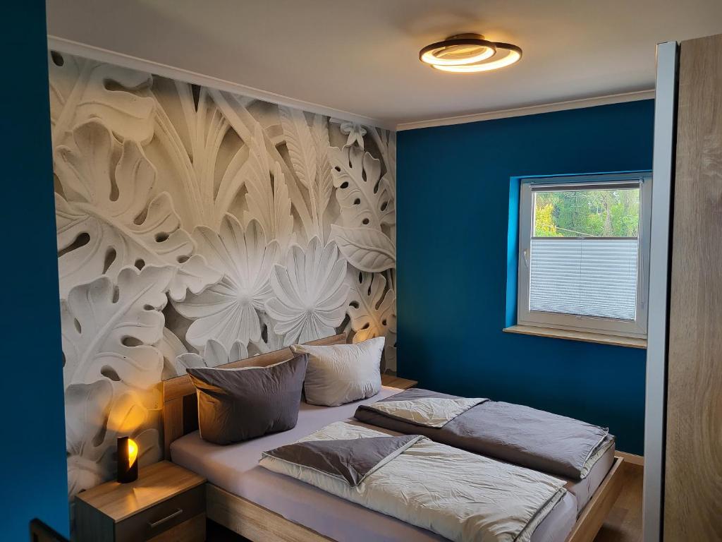 - une chambre dotée d'un lit avec un mur bleu dans l'établissement gapart - Apartments mit Küche, à Leipzig