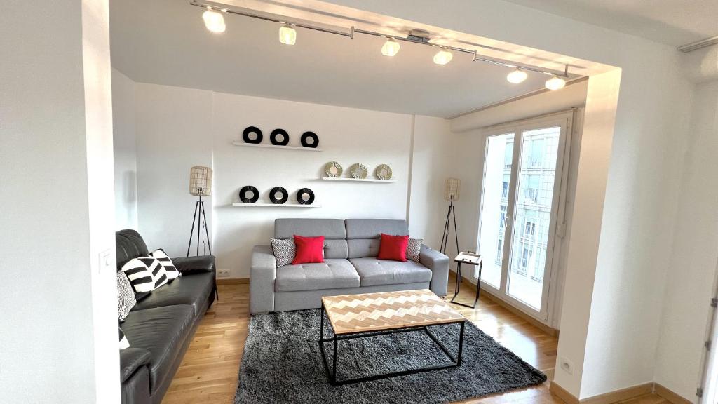 sala de estar con sofá y mesa en Superbe appartement en centre-ville, 20min de Paris, 5 min d&#39;Enghien, en Saint-Gratien
