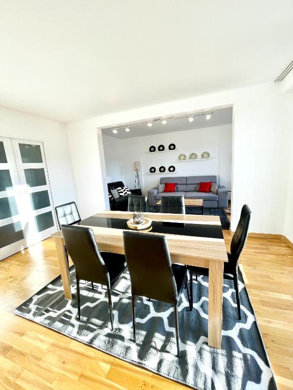 comedor y sala de estar con mesa y sillas en Superbe appartement en centre-ville, 20min de Paris, 5 min d&#39;Enghien, en Saint-Gratien