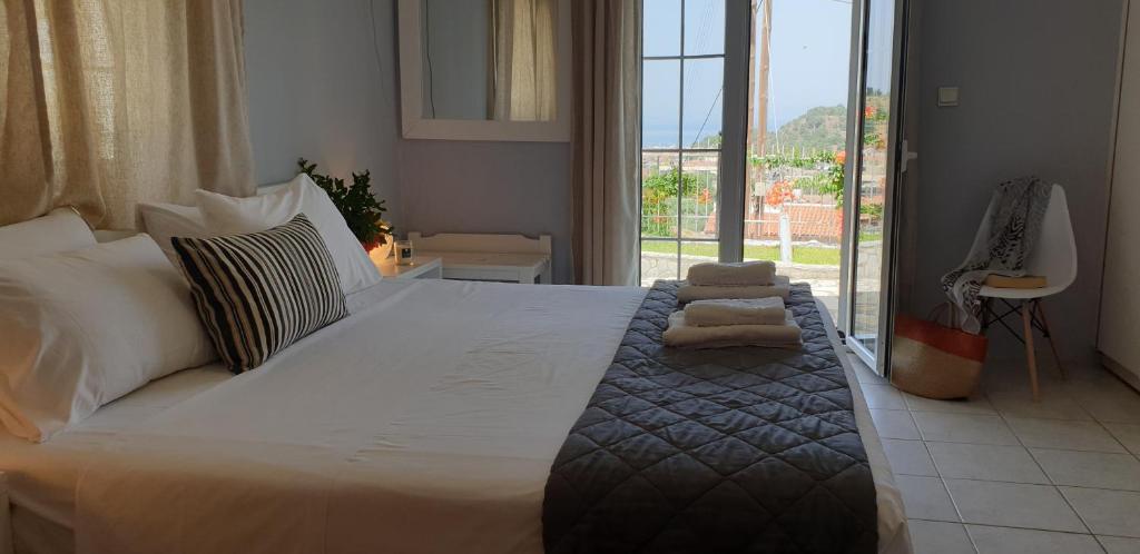 a bedroom with a large bed with a large window at Sivotahomes-blu in Syvota
