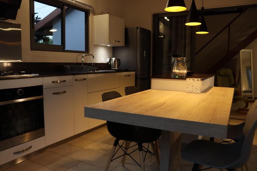 a kitchen with a wooden table and a counter top at Luxury Cosy Guesthouse in Pamplemousses Village