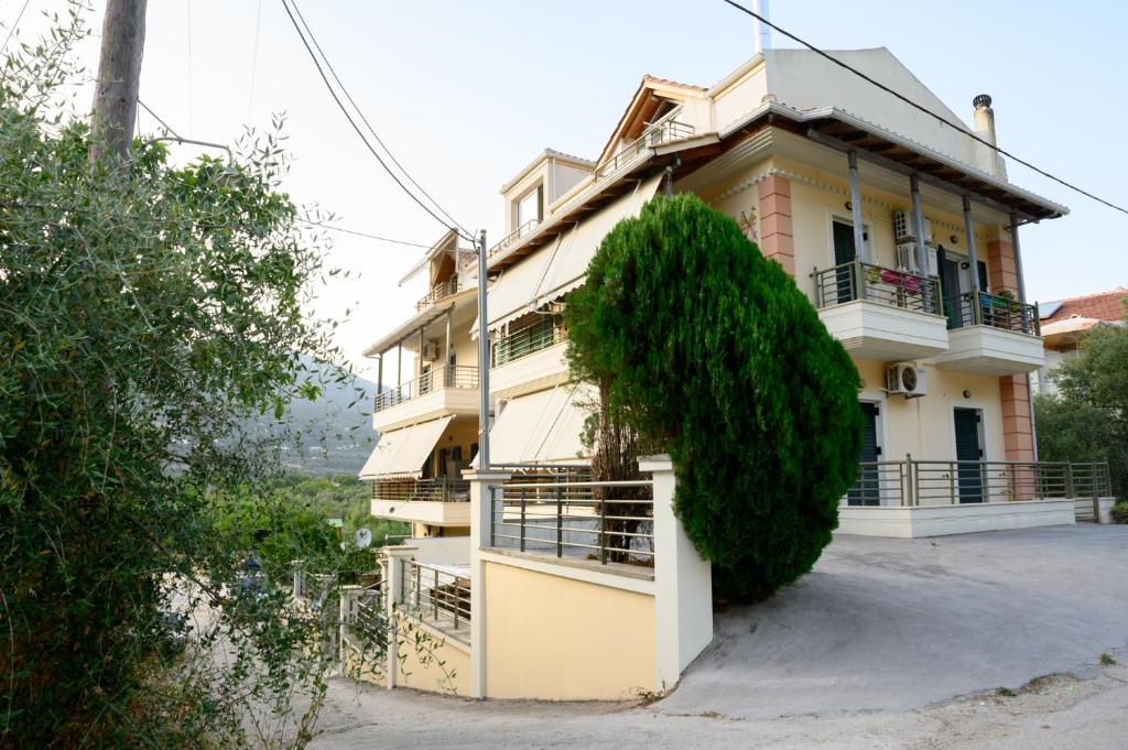 a house with a large bush on the side of it at Dinos Apartments in Vasiliki