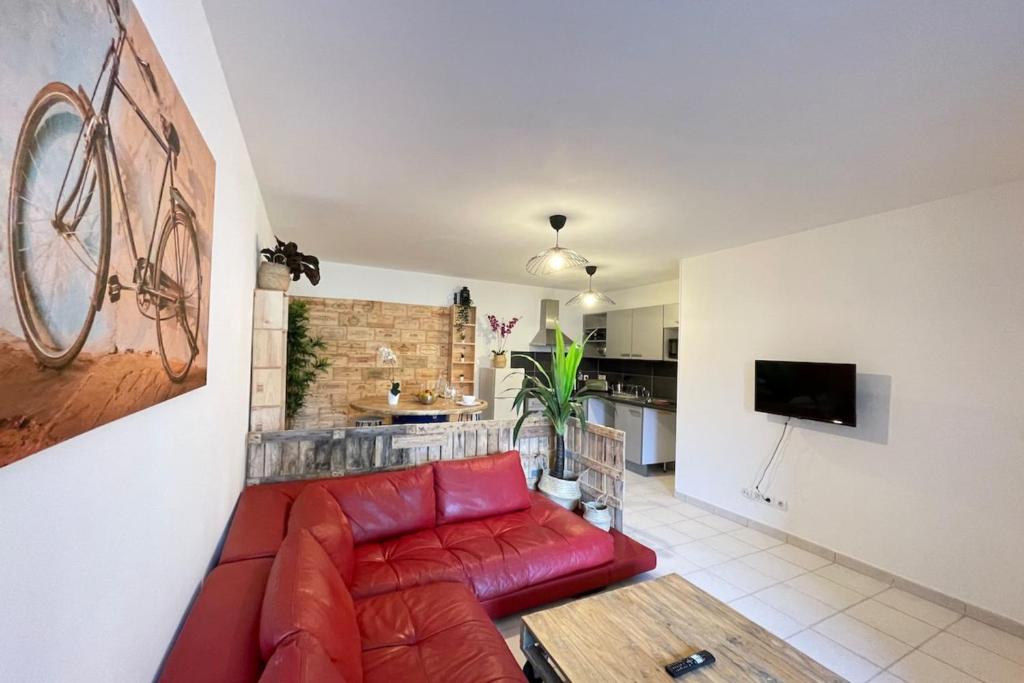 un salon avec un canapé rouge et une télévision dans l'établissement La Cave Proche gare Centre-Ville  Wifi-Netflix, à Marseille