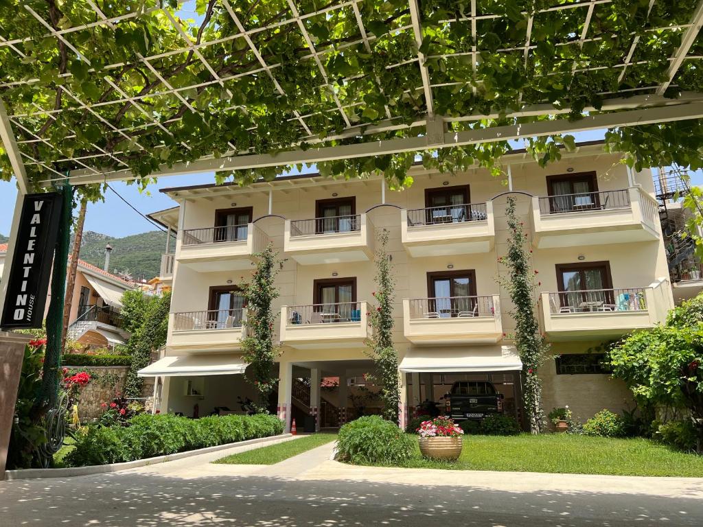 a large white building with windows and plants at Valentinos House in Parga