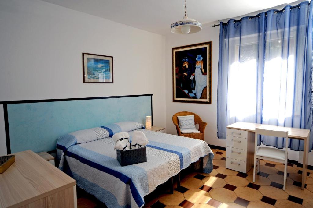 a bedroom with a bed and a table and a chair at Appartamento Parco Tarragona in Alghero