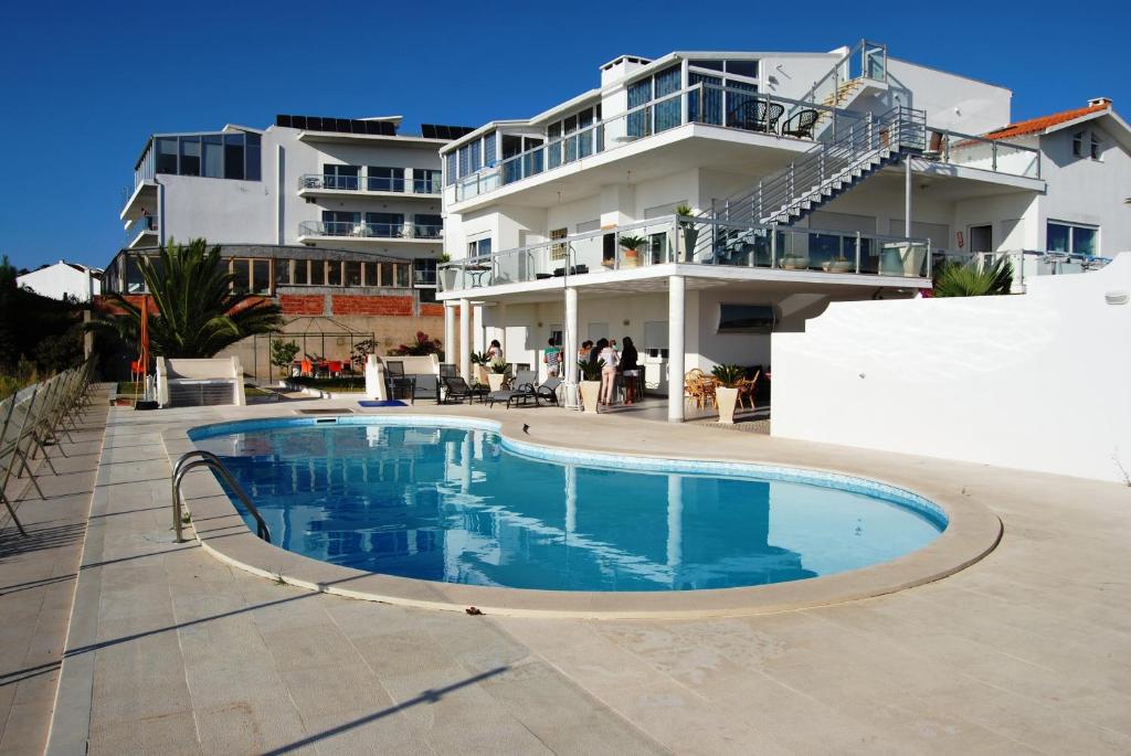 a swimming pool in front of a building at Apartamentos 7 saias in Nazaré