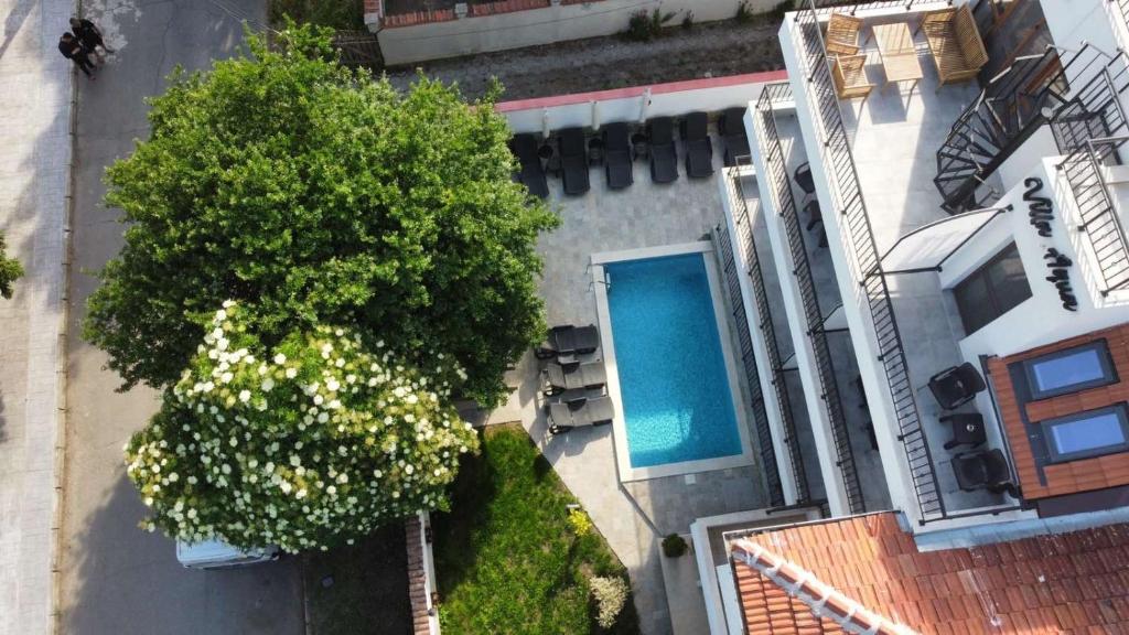 uma vista superior de uma casa com uma árvore e uma piscina em Villa Aqua Family Hotel em Burgas