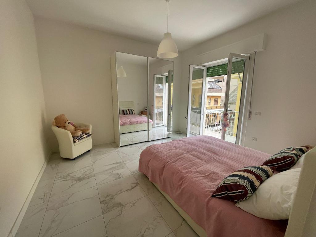 um quarto com uma cama, uma cadeira e espelhos em Incantevole Appartamento - Sentiero al Mare em San Benedetto del Tronto