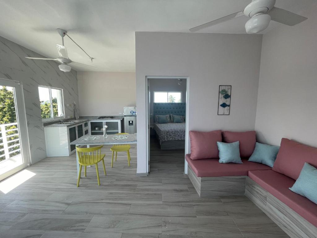 a living room with a red couch and a kitchen at Apartamentos La Torre in Río San Juan