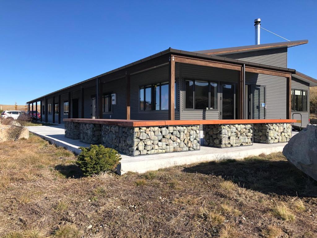 a house with a stone wall at Tekapo Ski Club Retreat in Lake Tekapo