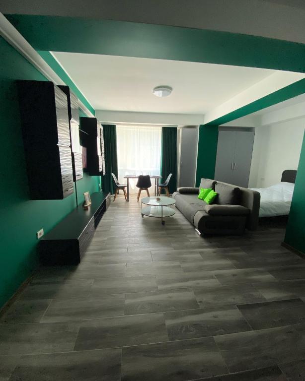un soggiorno con pareti verdi e un divano di Green Studio a Mamaia Nord - Năvodari
