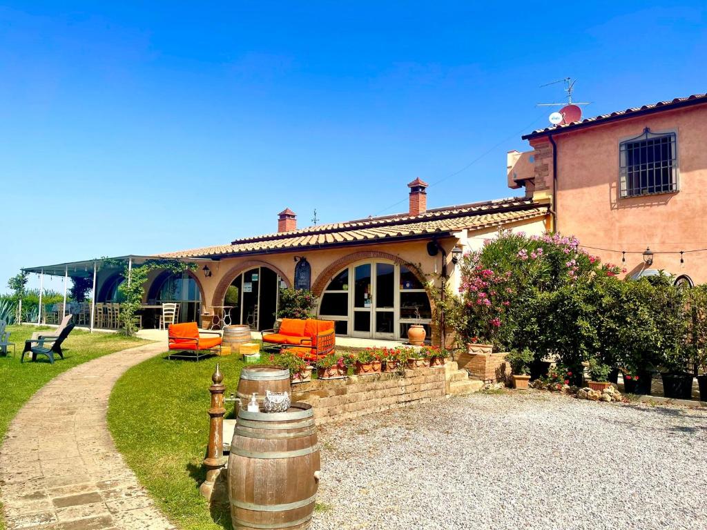 Uma casa com um barril à frente. em La Locanda della Vecchia Hosteria em Gavorrano