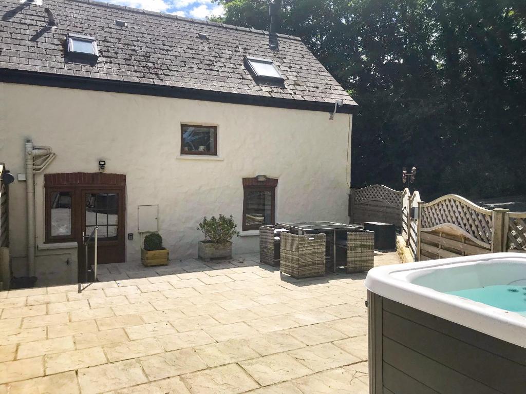 a backyard with a hot tub and a house at 1 The Barn in Haverfordwest