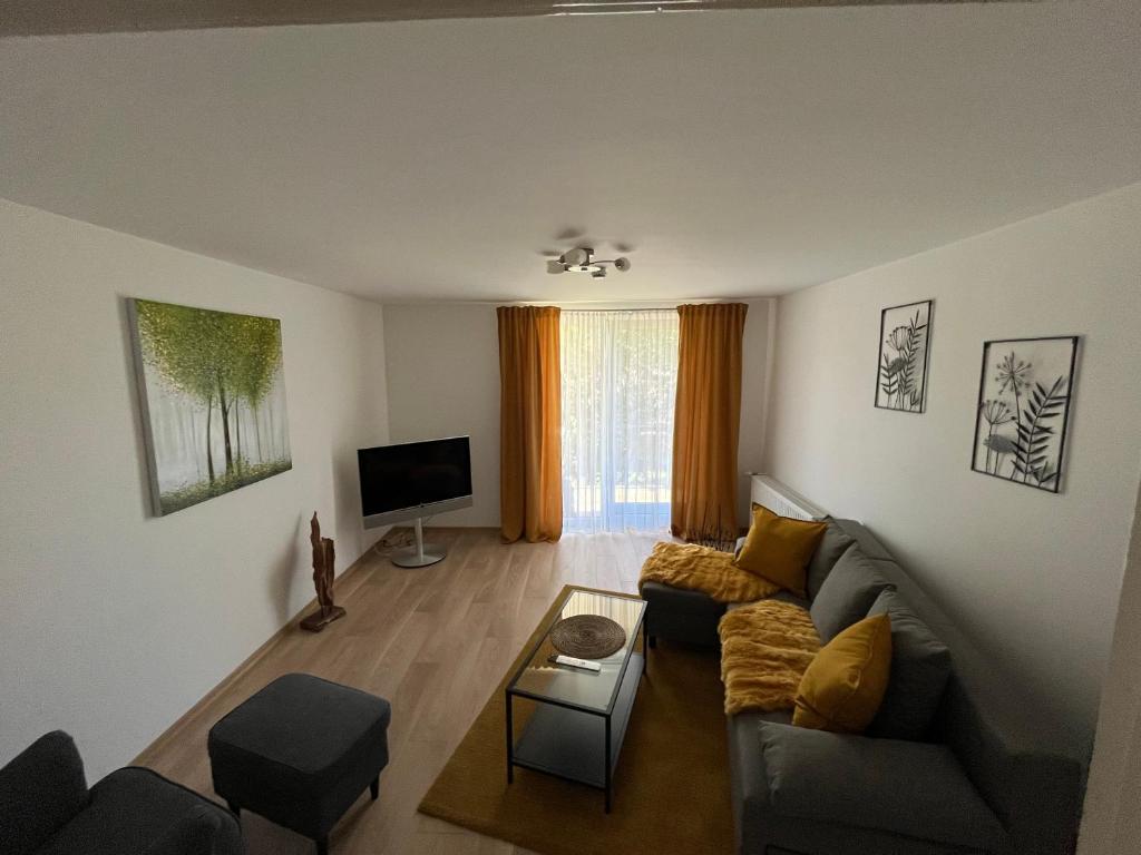 a living room with a couch and a tv at Ferienwohnung Bergstraße in Wilhelmsfeld